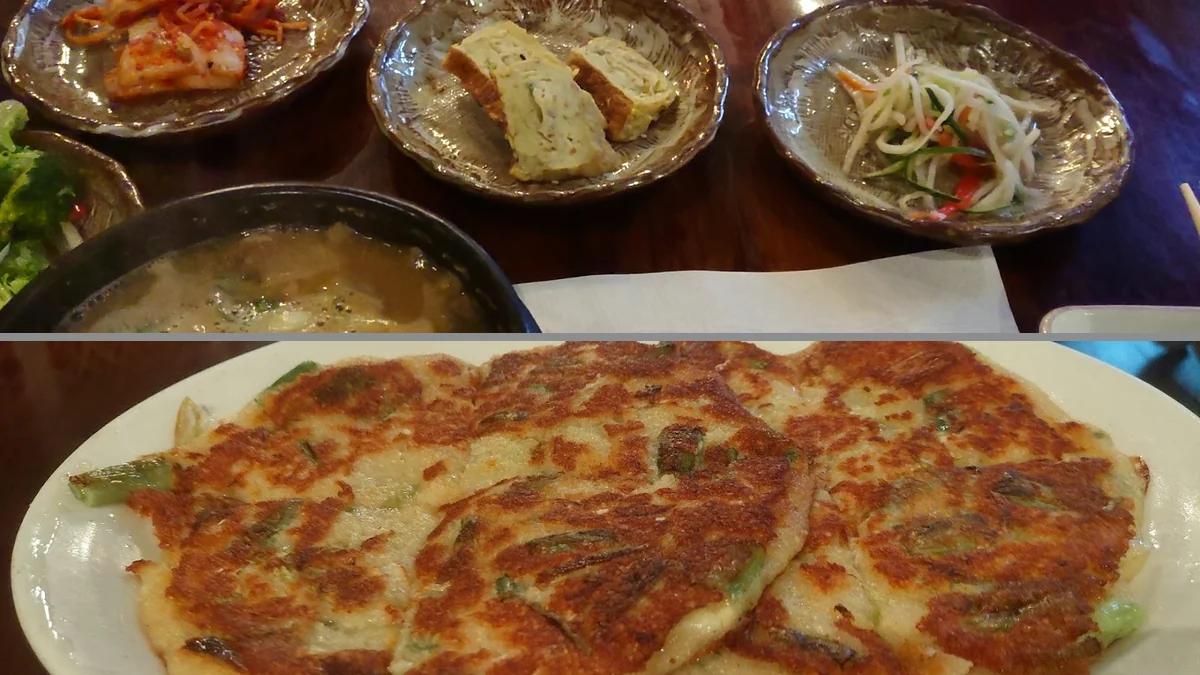 Plates of traditional Korean dishes on a dining table.